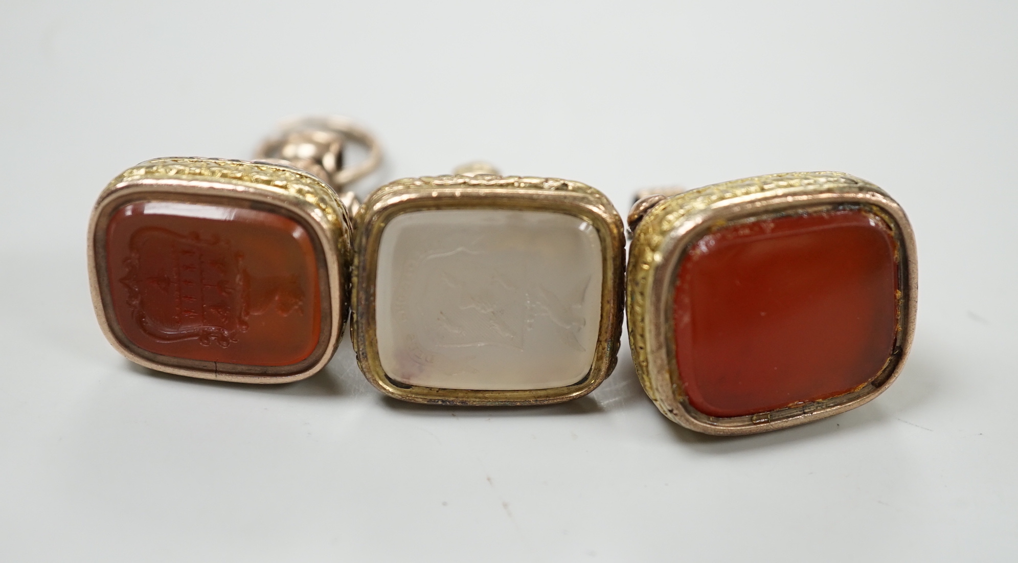 Three assorted Georgian gold plated and chalcedony set fob seals, two with carved matrix, approx. 35mm.